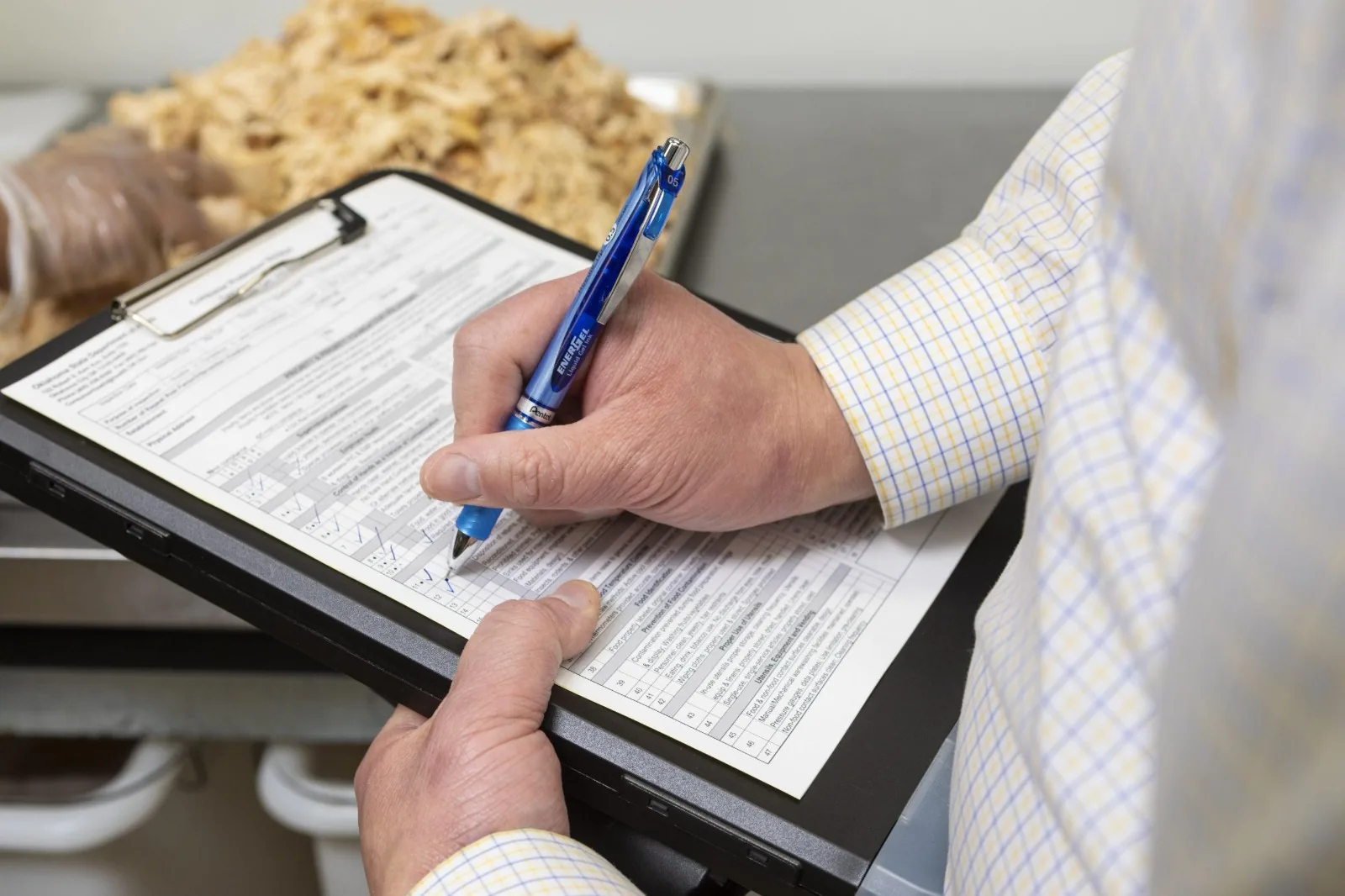 Consultant completing a detailed inspection report during a compliance audit